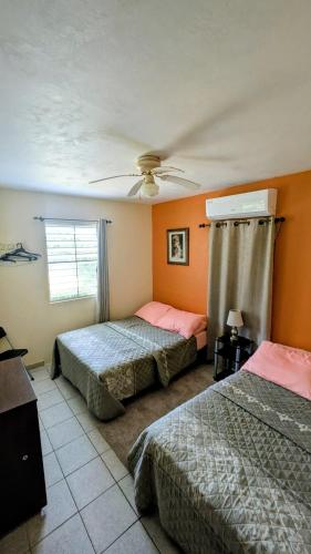 a bedroom with two beds and a ceiling fan at Fajardo Peaceful Place in Playa Sardinera