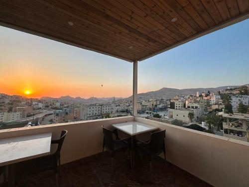 a balcony with a table and chairs and a view of a city at Petra Sky Hotel in Wadi Musa