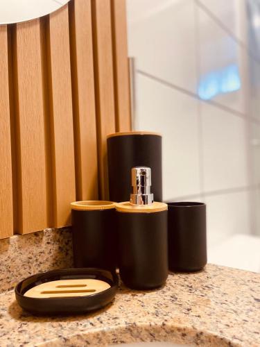 a bathroom counter with a toaster and three cups at Pousada Casa Californiana - Garopaba in Garopaba