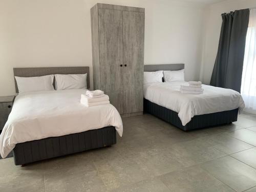 two beds sitting next to each other in a bedroom at Florencepalms resort & Spa in Marble Hall