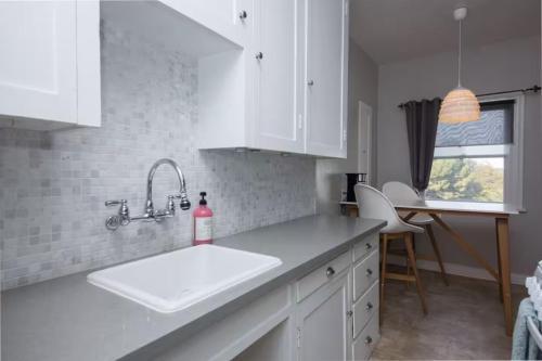 a kitchen with white cabinets and a white sink at The Riviera in San Pedro
