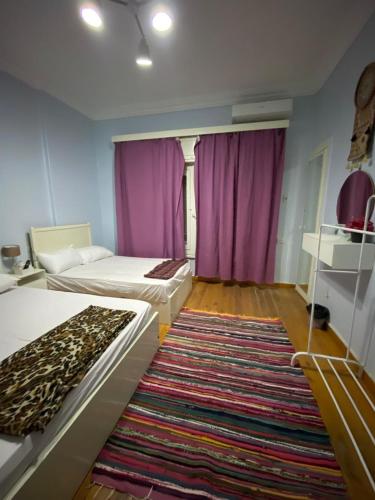 a bedroom with two beds and a large rug at Menna's home in Cairo