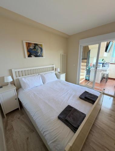 a bedroom with a large bed with two towels on it at Casa Ricardo Penthouse in Sitio de Calahonda
