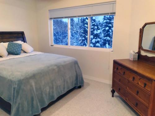 a bedroom with a bed and a dresser and a window at Moosedance 2 bedroom suite, beautiful views in Anchorage