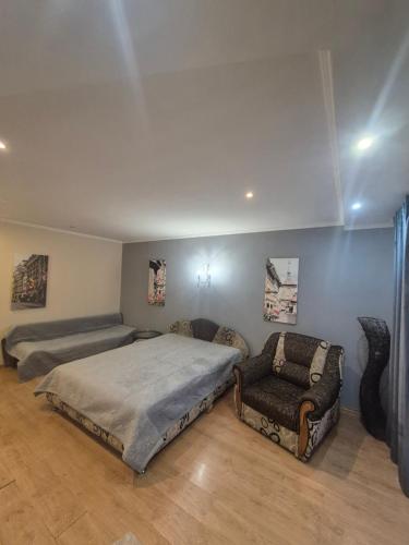 a bedroom with two beds and a chair in it at Апартаменты in Izmail