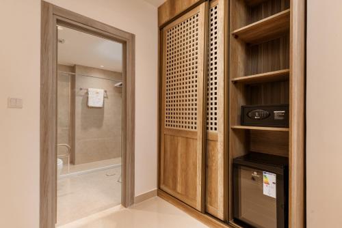 a bathroom with a shower and a walk in closet at Golden Pillar Hotel in Aqaba