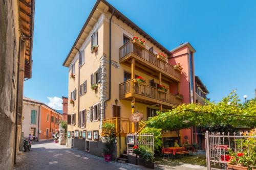 a building with balconies and flowers on a street at Hotel Dolomiti in Malcesine