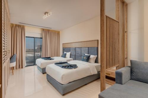 a hotel room with two beds and a couch at Golden Pillar Hotel in Aqaba