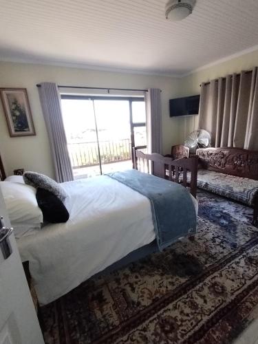 a bedroom with a bed and a large window at The Treehouse! in Struisbaai