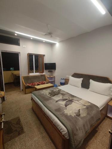 a bedroom with a large bed and a couch at Hotel Priyanka - 750 metres from nakki lake Near Bus Stand in Mount Ābu