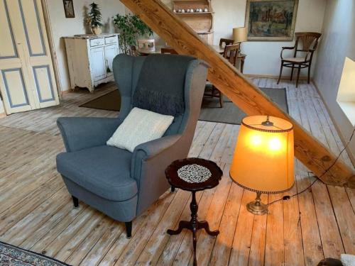 a living room with a blue chair and a lamp at Apartment AMARCORD Loft by Interhome in Biasca