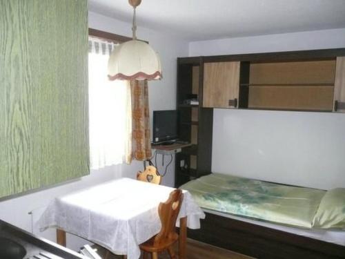 a bedroom with a bed and a table and a window at Apartment Chesa Margretta by Interhome in Sils Maria