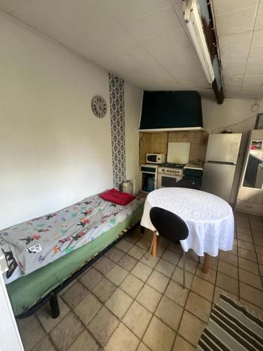 a small kitchen with a bed and a table at Petit studio cosy in Cersay