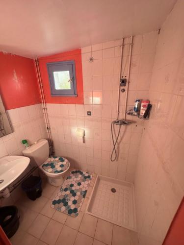 a bathroom with a shower and a toilet and a sink at Petit studio cosy in Cersay