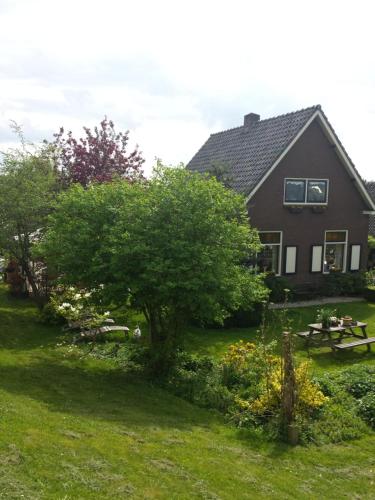 een huis met een picknicktafel en een boom in de tuin bij B&B aan de Limes in Maurik in Maurik