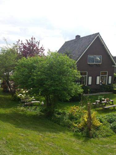 ein Haus mit einem Picknicktisch und einem Baum im Hof in der Unterkunft B&B aan de Limes in Maurik in Maurik