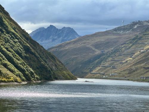 a river in the middle of a valley with mountains at Apartment Blue Alpine Lodge by Interhome in Rueras