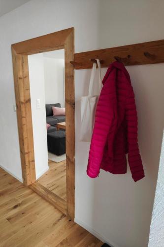 a mirror with a pink sweater hanging on a wall at Apartment Günter by Interhome in Sagogn