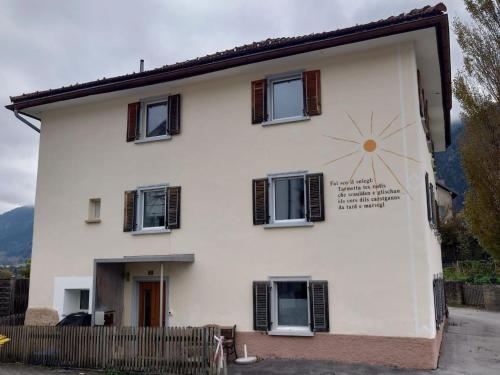 a white house with a clock on the side of it at Apartment Günter by Interhome in Sagogn