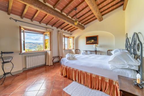 a bedroom with a large bed and a large window at Agriturismo Panzanello in Panzano