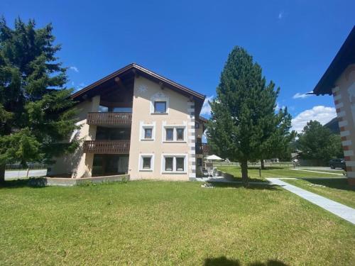 a large house with a large yard with trees at Apartment Sassella 2a by Interhome in La Punt-Chamues-ch