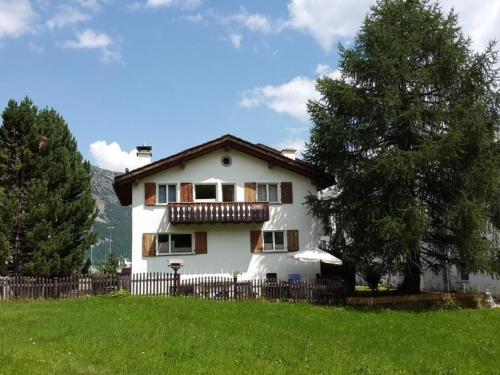 a white house with a fence and a tree at Apartment 3 Bettwohnung by Interhome in Sils Maria