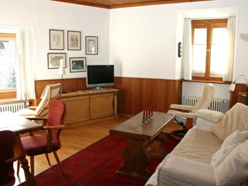 a living room with a couch and a tv at Apartment Chesa Müller by Interhome in Zuoz