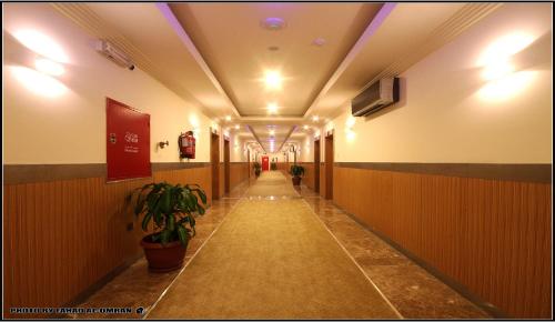 an empty hallway with a plant in a building at Taraf Yanbu 2 in Yanbu
