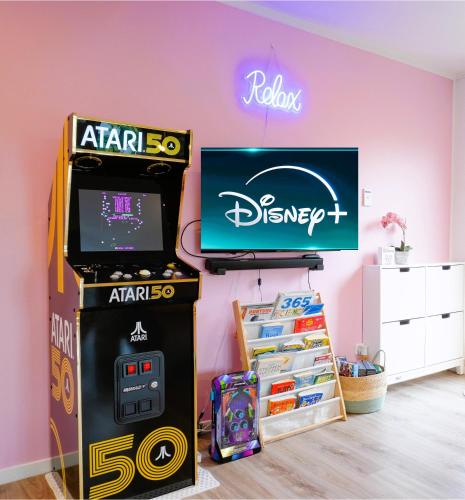 a video game machine next to a disney tv at Train, Zoo & Eden Park Nearby - Arcade, Disney Plus- Free Parkings- Central & Peaceful in Auckland