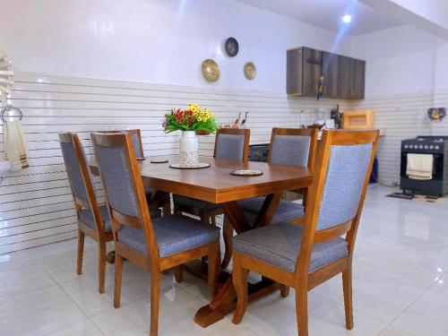 a dining room table and chairs with flowers on it at Njiwa suites 1034 in Mombasa