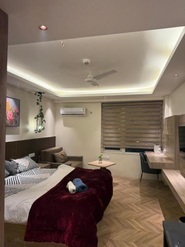 a bedroom with a large bed and a desk at Luna Stays in Greater Noida