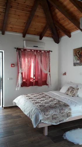 a bedroom with a bed with a red window at Mango Holiday Rooms in Had Nes