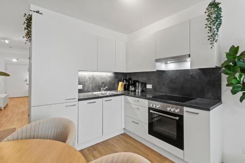 a kitchen with white cabinets and black counter tops at U1 Metro Nearby - 1-BR - fast Wi-Fi in Vienna