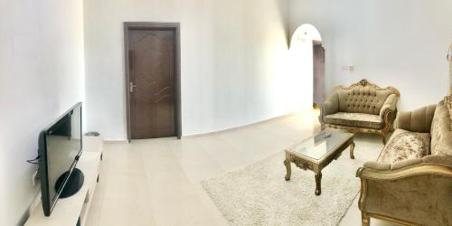 a living room with a couch and a tv at Masirah oyster in Ḩilf