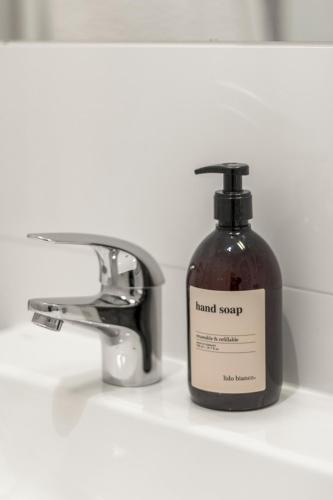 a bottle of hand soap sitting next to a sink at U1 Metro Nearby - 1-BR - fast Wi-Fi in Vienna