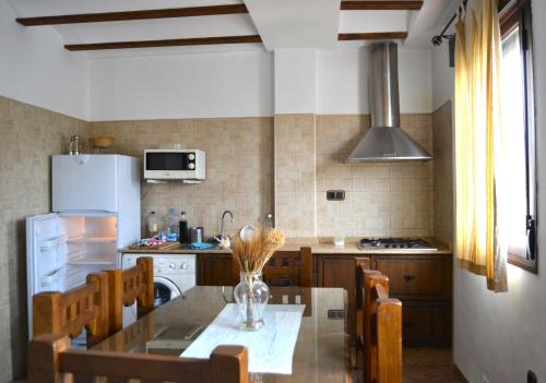 a kitchen with a table with chairs and a refrigerator at Casas rurales la Codorniz in Almaciles