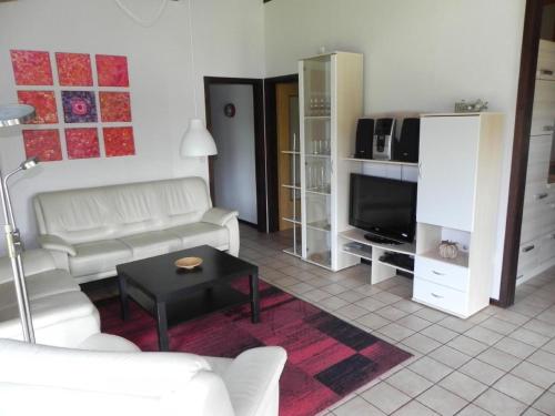 a living room with a white couch and a tv at Holiday Home by Interhome in Großwürden