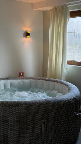 a large bath tub in a room with a window at AHAVA Spa Residence in Žabljak