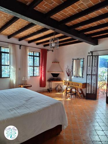a bedroom with a bed and a table and windows at Hotel Cielito Lindo, Taxco in Taxco de Alarcón