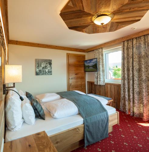 a bedroom with a bed in a room at Panorama Hotel Leidingerhof in Mondsee
