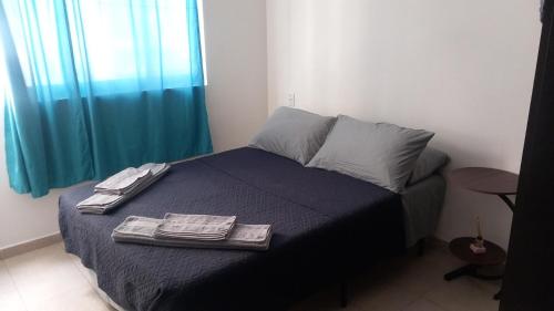 a bedroom with a bed with two towels on it at Aeropuerto Pantitlán CDMX in Mexico City
