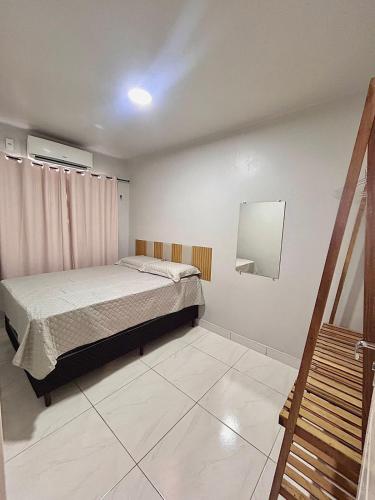 a bedroom with a bed and a mirror on the wall at Apartamento CONFORT 2Q in Rio Branco