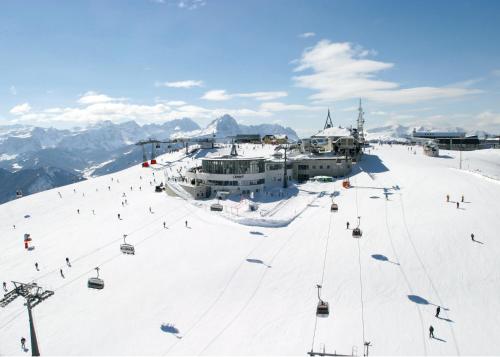 a ski resort with a ski lift on a snow covered slope at Boutique Hotel Am Park in Valdaora
