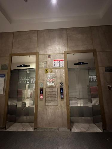 two elevators in a building with two glass doors at AuraStays in Dargai