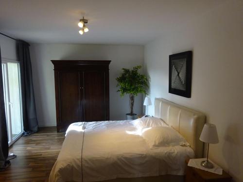 a bedroom with a bed and a potted plant at Apartment Rheintalblick 2 by Interhome in Linz am Rhein