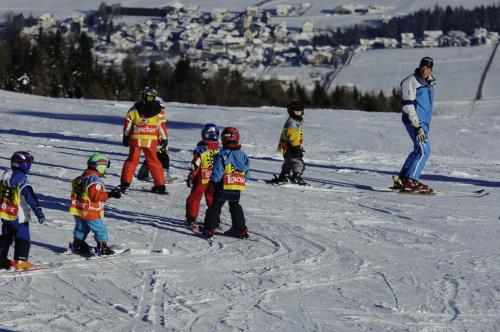 a group of children are learning to ski in the snow at Boutique Hotel Am Park in Valdaora