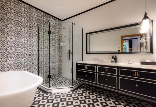 a bathroom with a tub and a shower and a sink at Hana Lodge in Rotorua