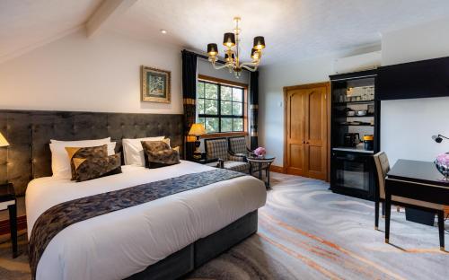 a bedroom with a bed and a desk in a room at Hana Lodge in Rotorua