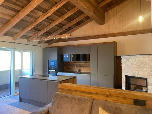 a living room with a couch and a kitchen at Ferienwohnungen Unterdürmoos Apartments mit Chalet-Charme auf 1050 m , Alleinlage in Annaberg im Lammertal