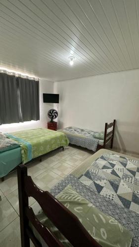 a room with three beds in a room at Suites da Bela 03 Caparaó in Caparaó Velho